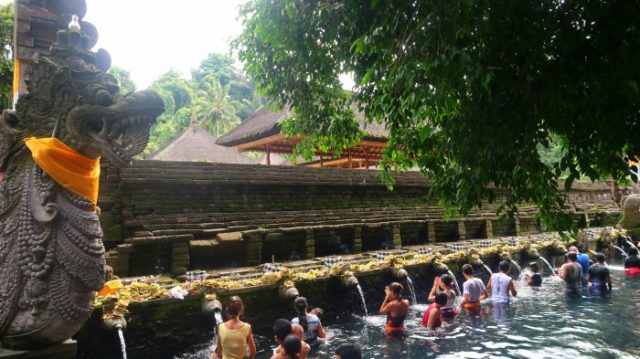 A purifying ritual in Tirta Empul temple - bathing in the holy spring water of Pakerisan river 