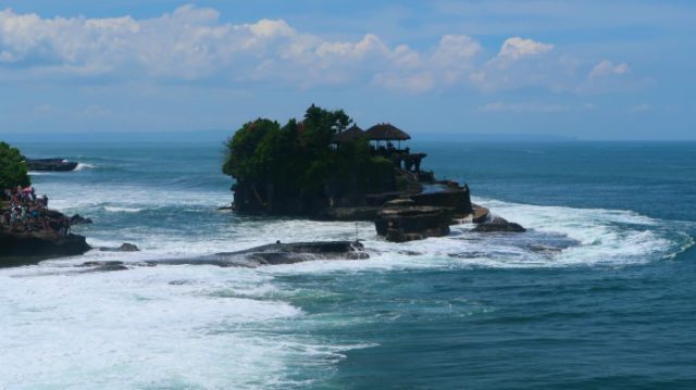 Tanah Lot temple on a tiny island in the middle of the blue sea