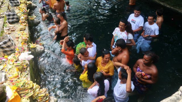 Locals during a purifying ritual in Tirta Empul Tampaksiring temple, Bali 