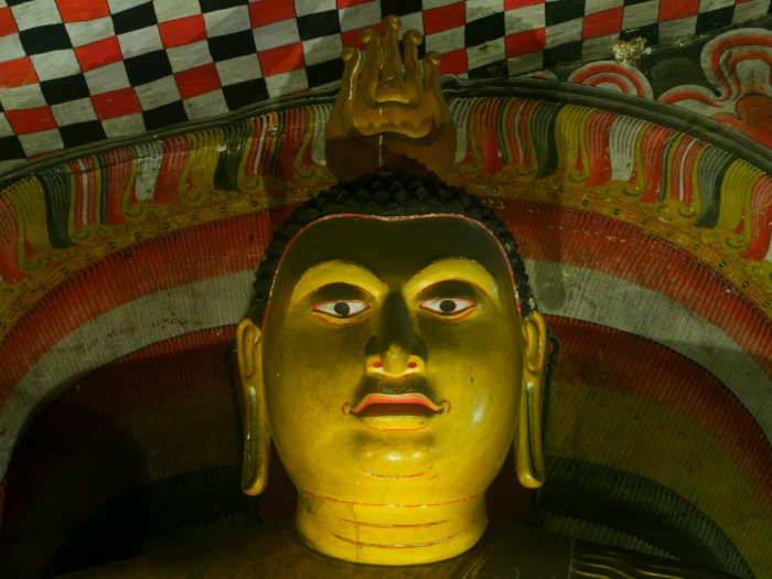 a closeup of a Buddha statue's head in the cave temple of Dambulla in Sri Lanka 