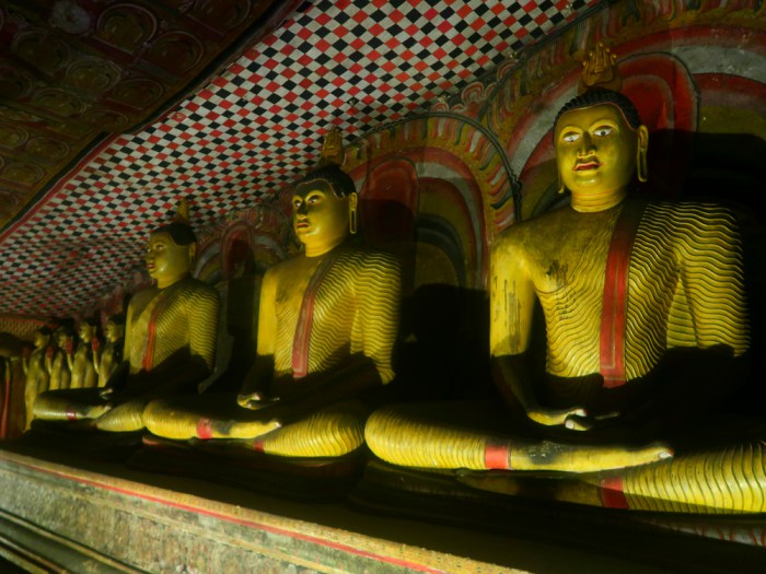big sitting buddha statues inside of Dambulla golden cave temple in sri lanka 