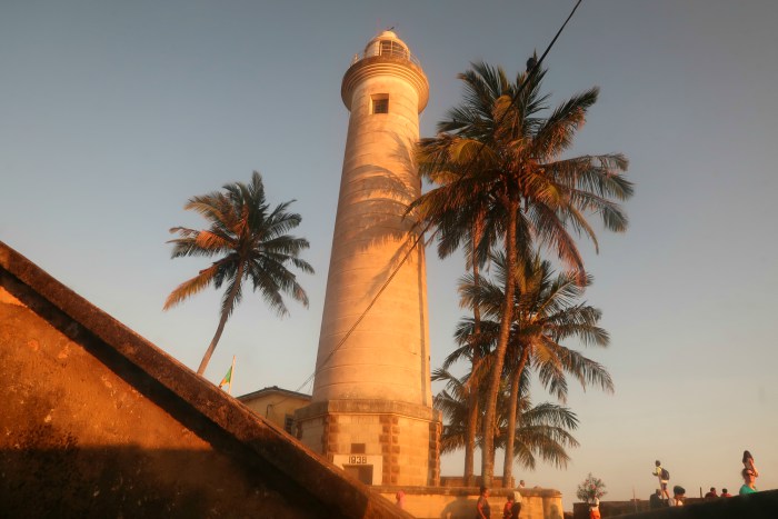 The lighthouse of Galle in sri lanka and tall palm trees 