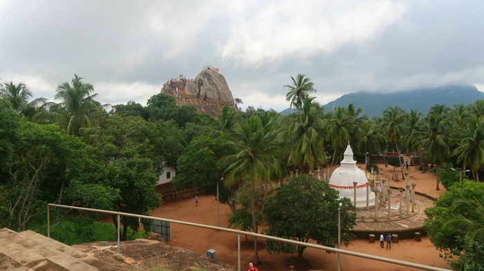 Mihintale stupa and mountain surrounded by lush green jungle and palm trees in Sri Lanka 