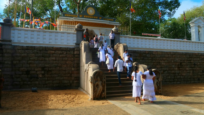 locals dressed in white on the way to the bodhi tree temple in sri lanka 