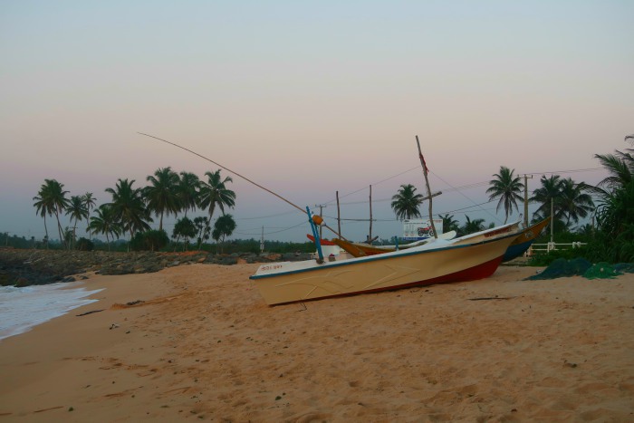 pastel sunset sky and the boat on the beach in unawatuna in sri lanka 