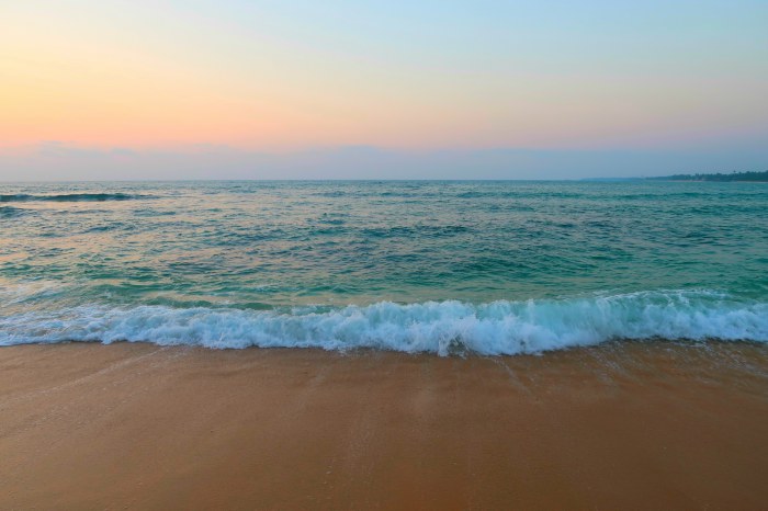waves on the beach and pastel sunset sky in unawatuna in sri lanka 
