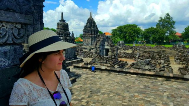 a girl standing in the middle of prambanan temple in java indonesia 