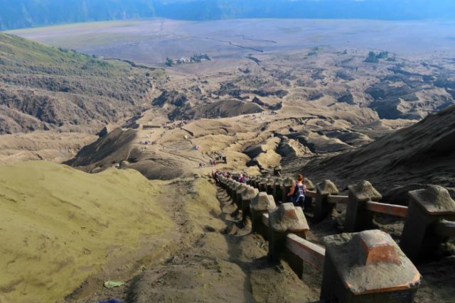 the stairway that leads to the edge of the bromo volcano crater and amazing lava formations in the distance - java indonesia 