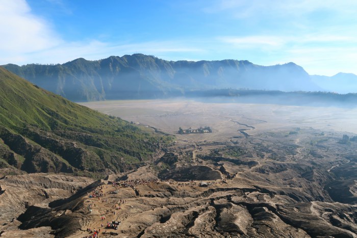 a huge volcano caldera of bromo tegger semeru volcanoes and a hindu temple in the distance in java indonesia 