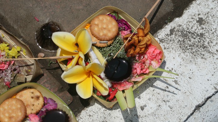 balinese offerings with flowers and food in tanah lot temple in bali indonesia 