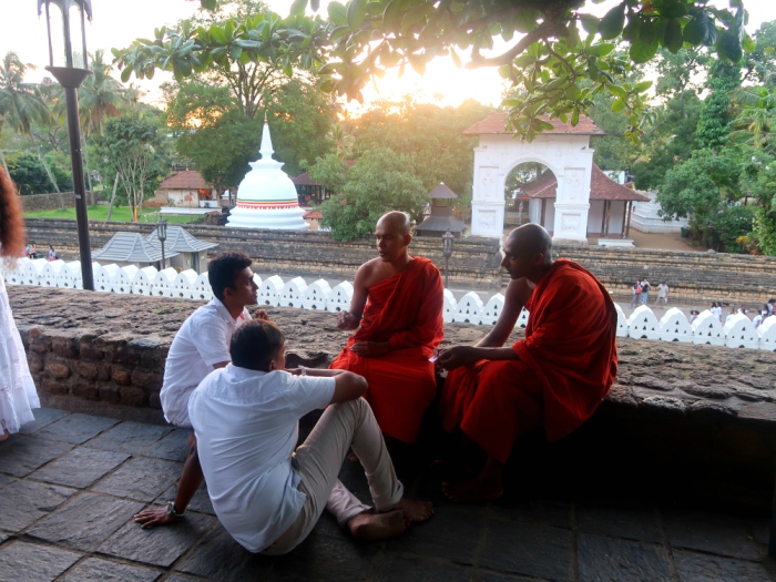 buddhist monks sitting and talking in the holy tooth relic temple in kandy in sri lanka 